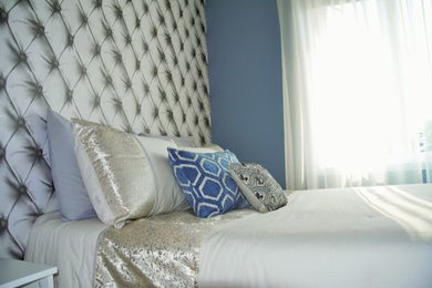 Ejemplo de habitación de invitados moderna pequeña con paredes azules y suelo de madera en tonos medios