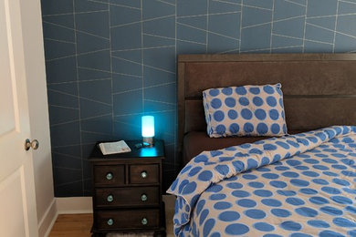 Diseño de habitación de invitados contemporánea de tamaño medio con paredes azules, suelo de madera en tonos medios y suelo marrón