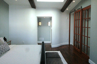 Modelo de dormitorio principal minimalista de tamaño medio con paredes verdes y suelo de madera oscura