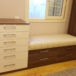 Immagine di una grande camera matrimoniale minimalista con pareti beige, pavimento in laminato e pavimento giallo