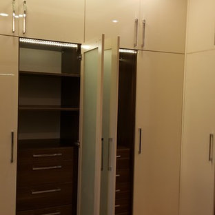 Immagine di una grande camera matrimoniale minimalista con pareti beige, pavimento in laminato e pavimento giallo