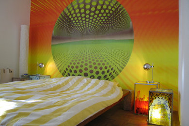 Imagen de dormitorio principal urbano de tamaño medio con paredes multicolor y suelo de madera en tonos medios