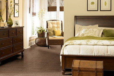 Imagen de dormitorio principal exótico grande con paredes beige y moqueta