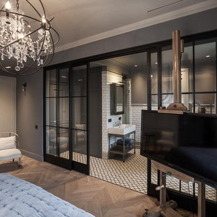 Imagen de dormitorio principal, urbano, grande, con paredes grises y suelo de madera en tonos medios