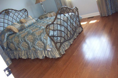 Ejemplo de habitación de invitados sin chimenea con paredes azules y suelo de madera en tonos medios