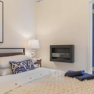 Imagen de dormitorio principal, actual, pequeño, con suelo de madera en tonos medios y chimeneas suspendidas
