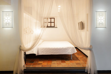 Modelo de habitación de invitados de estilo americano pequeña con paredes blancas y suelo de baldosas de terracota