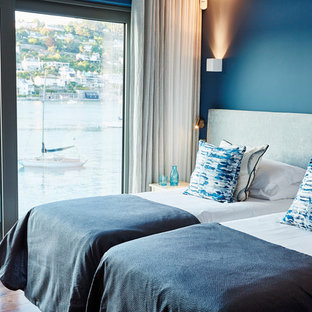 Foto de habitación de invitados actual, de tamaño medio, con paredes azules y suelo de madera oscura