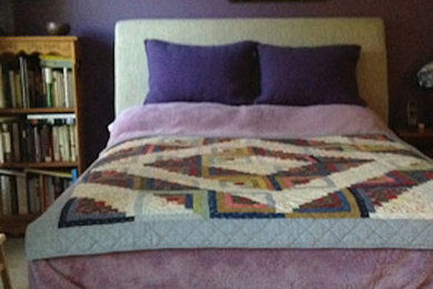 Modelo de dormitorio bohemio sin chimenea con paredes púrpuras y moqueta