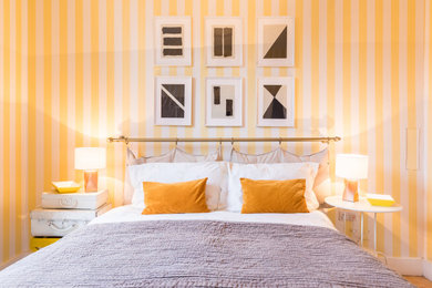 マイアミにある中くらいなコンテンポラリースタイルのおしゃれな客用寝室 (黄色い壁、無垢フローリング、ベージュの床、壁紙) のレイアウト