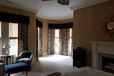 This is an example of a large victorian master bedroom in Other with brown walls, carpet, a standard fireplace, a tiled fireplace surround and beige floors.