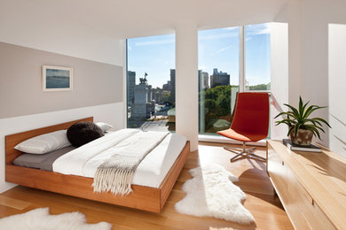 Bedroom - modern medium tone wood floor bedroom idea in New York with white walls