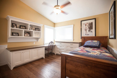Imagen de habitación de invitados clásica de tamaño medio sin chimenea con paredes beige, suelo de madera oscura y suelo marrón