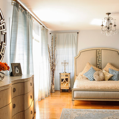 Mid-sized elegant master medium tone wood floor bedroom photo in New York with gray walls and no fireplace