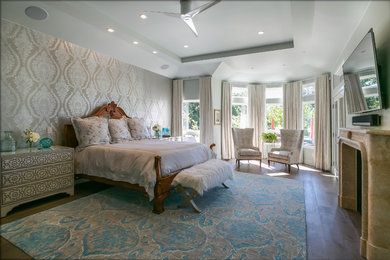 サンフランシスコにある広いトランジショナルスタイルのおしゃれな主寝室 (グレーの壁、濃色無垢フローリング、標準型暖炉、石材の暖炉まわり、茶色い床) のインテリア
