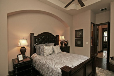 Ejemplo de dormitorio principal tradicional grande sin chimenea con paredes beige, suelo de madera oscura y suelo marrón
