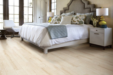 Inspiration for a large traditional bedroom in New York with brown walls and light hardwood flooring.