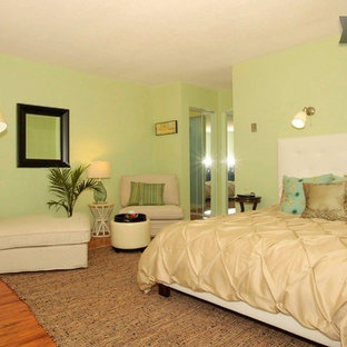 Modelo de habitación de invitados contemporánea, pequeña, con paredes verdes y suelo laminado