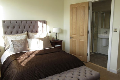 This is an example of a large contemporary master bedroom in London with white walls, carpet and brown floors.