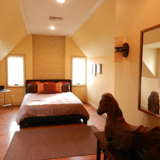 Imagen de dormitorio tipo loft, contemporáneo, de tamaño medio, con paredes amarillas y suelo de madera en tonos medios