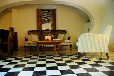 Esempio di una camera matrimoniale mediterranea di medie dimensioni con pareti bianche e pavimento in cemento
