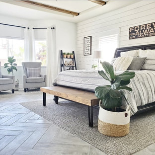 Country Hauptschlafzimmer mit weißer Wandfarbe, Keramikboden, Kamin, Kaminumrandung aus Holzdielen, grauem Boden, freigelegten Dachbalken und Holzdielenwänden in Las Vegas