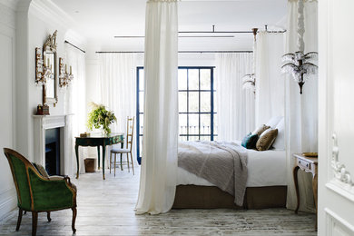 Diseño de dormitorio principal clásico renovado de tamaño medio con paredes blancas, suelo de madera en tonos medios, todas las chimeneas y suelo gris