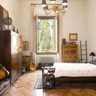 Esempio di una camera matrimoniale boho chic con pareti bianche, parquet scuro e nessun camino