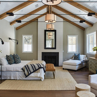 Klassisches Hauptschlafzimmer mit grauer Wandfarbe, braunem Holzboden und Kamin in Los Angeles