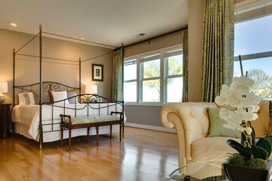 На фото: огромная хозяйская спальня в стиле неоклассика (современная классика) с серыми стенами, светлым паркетным полом, стандартным камином и фасадом камина из камня с