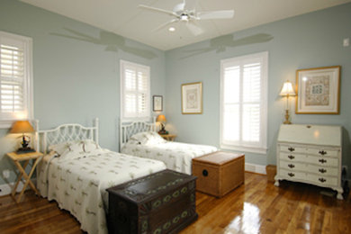 Large medium tone wood floor bedroom photo in Charleston with blue walls