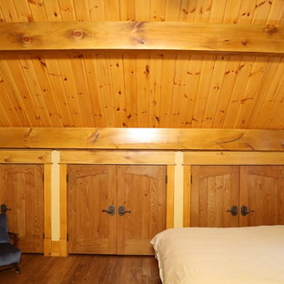 Foto de dormitorio tipo loft, de estilo americano, grande, con paredes amarillas y suelo de madera en tonos medios
