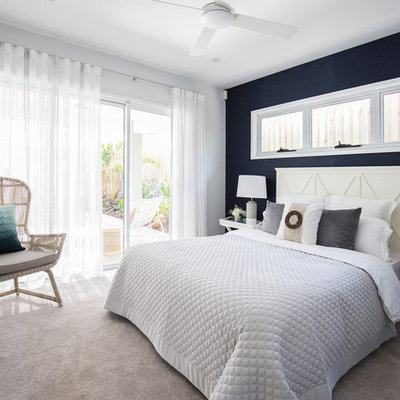 Example of a mid-sized beach style guest carpeted bedroom design in Brisbane with blue walls