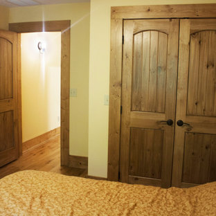 Diseño de habitación de invitados rústica, grande, con paredes beige, suelo de madera oscura y suelo multicolor