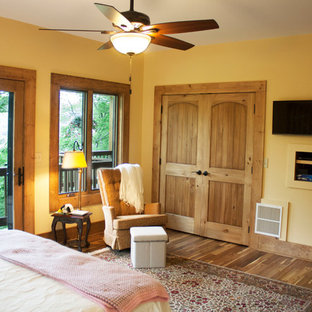 Foto de dormitorio principal, rústico, grande, con paredes beige, suelo de madera oscura y suelo multicolor