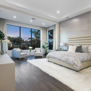 Modernes Schlafzimmer mit grauer Wandfarbe, dunklem Holzboden, braunem Boden, Tapetenwänden und eingelassener Decke in Miami
