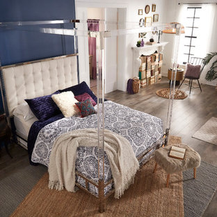 Diseño de dormitorio principal, bohemio, de tamaño medio, con paredes azules, suelo de madera clara, chimenea tradicional, marco de chimenea de yeso y suelo marrón