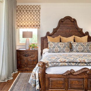 Elegant dark wood floor and brown floor bedroom photo in Austin with white walls