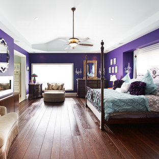 Imagen de dormitorio principal, contemporáneo, de tamaño medio, con paredes púrpuras, suelo de madera oscura, chimenea de doble cara, marco de chimenea de metal y suelo marrón