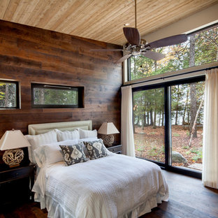 Ejemplo de dormitorio principal, rural, grande, con paredes beige, suelo de madera oscura, suelo marrón y chimeneas suspendidas