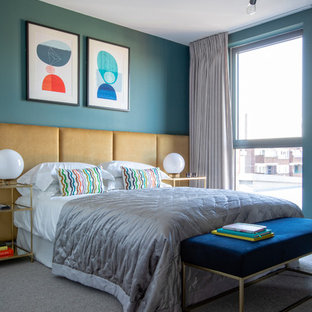 This is an example of a contemporary grey and brown bedroom in London with blue walls, carpet and grey floors.