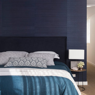 Design ideas for a mid-sized beach style master bedroom in Sydney with blue walls, carpet and brown floor.