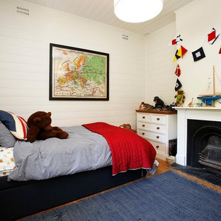 Foto de habitación de invitados campestre, pequeña, con paredes blancas, suelo de madera clara, chimenea tradicional, marco de chimenea de yeso y suelo marrón