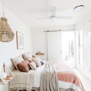 Inspiration for a beach style master bedroom in Sunshine Coast with white walls, carpet and beige floor.