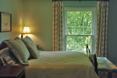 Elegant master medium tone wood floor and brown floor bedroom photo in Nashville with green walls