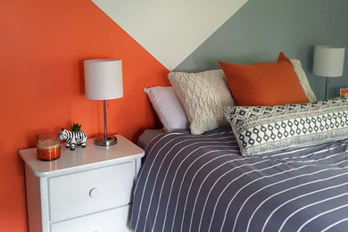 Bedroom - mid-sized modern guest medium tone wood floor and brown floor bedroom idea in Boston with multicolored walls