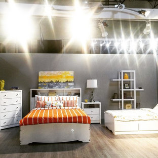 Modelo de dormitorio tipo loft, tropical, grande, con paredes blancas y suelo laminado