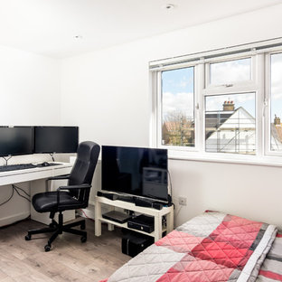 Diseño de dormitorio tipo loft, moderno, pequeño, sin chimenea, con paredes beige, suelo laminado y suelo beige