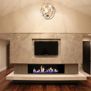 Imagen de dormitorio principal, actual, extra grande, con paredes beige, suelo de madera oscura, chimenea lineal y marco de chimenea de yeso