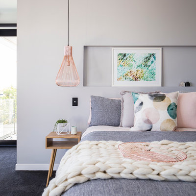 Example of a large trendy master carpeted bedroom design in Gold Coast - Tweed with gray walls and no fireplace